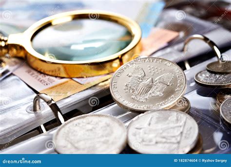 Silver Dollar and Numismatic Coins with Magnifying Glass Stock Photo ...