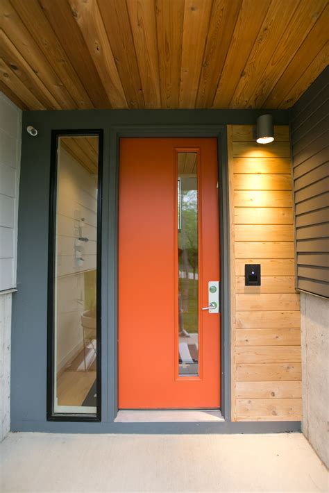 Mid-century modern inspired orange front door on two-toned grey exterior