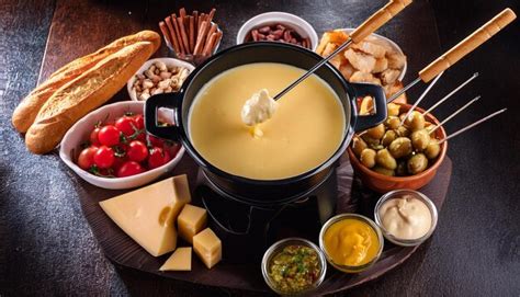 Warm cheese fondue with bread dips and olives a rustic culinary scene ...