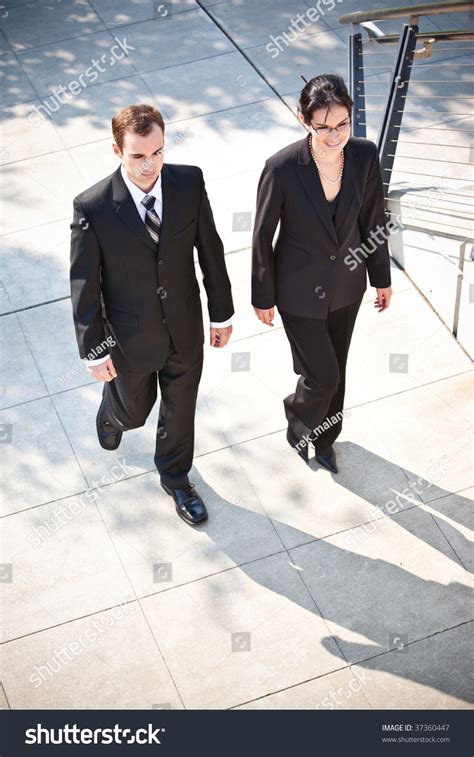 Two Business People Walking Side by Side 的图像结果