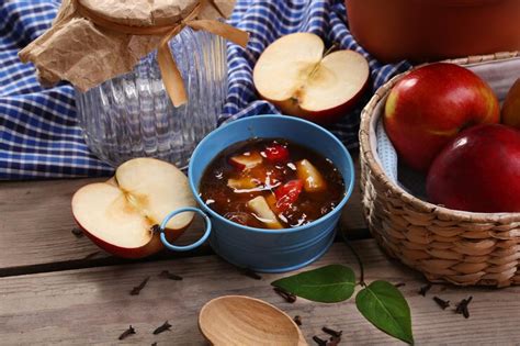 Apple jam in pail and fresh red apples on wooden table closeup ...