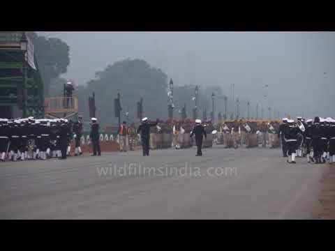 Military marching band performs during an official parade on a wide boulevard