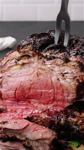 This prime rib roast gets an Italian-inspired kick with Dijon mustard, garlic, fresh herbs, and red pepper flakes. Roasted over red wine and beef broth, the richly seasoned beef develops an incredible, flavorful crust as the pan drippings turn into an easy au jus for serving! #silkroadrecipes #dinner #primerib #holidayroast #ribroast
