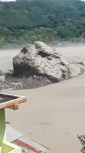 Huge boulder rolls down river