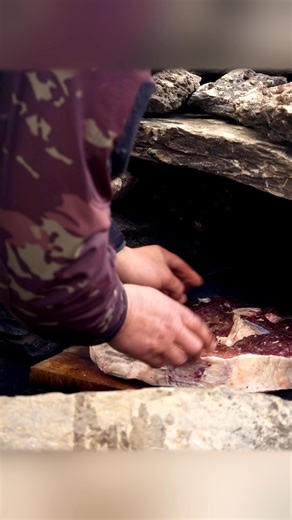 Savor the sight of marinated meat grilling over an open fire, infused with herb butter. A true outdoor cooking delight! #GrilledMeat #OutdoorCooking #OpenFire #Cooking | Wilderness Grill