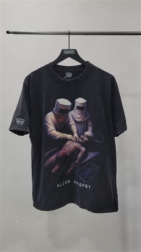 The Alien Autopsy Vintage Heavyweight T-Shirt by SAUCER captures one of the most infamous moments in UFO history. Inspired by the alleged 1947 Roswell crash recovery, the design recreates the chilling scene of two hazmat-suited figures performing an autopsy on a classic grey alien. Printed on a black, vintage-washed tee for that perfectly broken-in, archival feel, this design is both a conversation starter and a wearable piece of UFO popular culture - crafted for those who know the story runs de