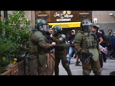 Protester kicks riot police during World Water Day protest in Chile
