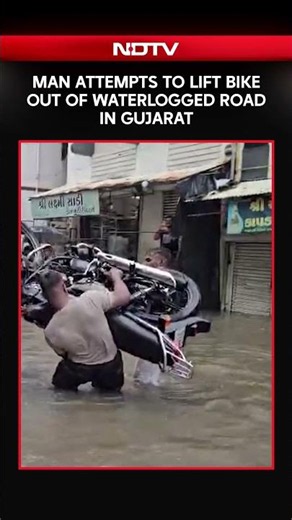 Gujarat Rains | Man Attempts to Lift Bike Out of Waterlogged Road in Gujarat