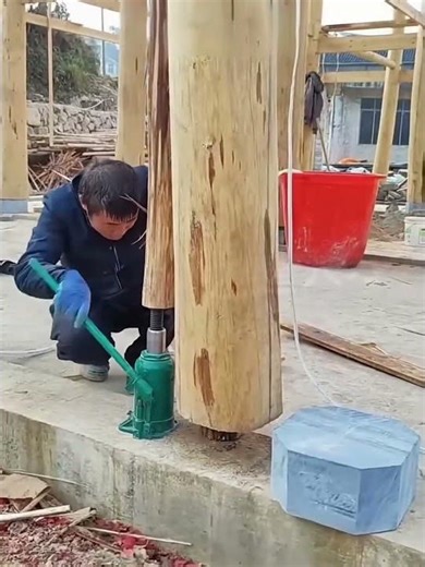Installation process of stone base under wooden frame with the help of jacks