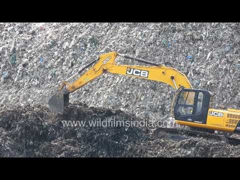 A JCB machine is seen operating at the Ghazipur landfill in Delhi