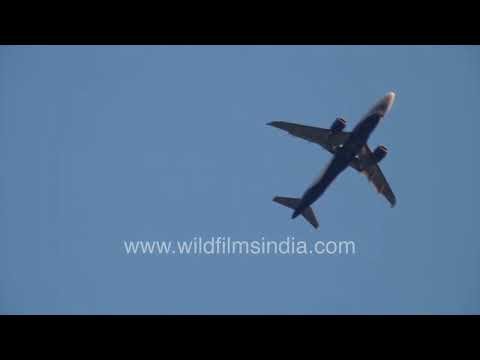 A commercial airplane seen from the ground with traffic noise nearby