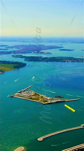 Vertical video. Venice, Italy. Aerial view over the Lido inlet, the fortified San Nicolo promonto...