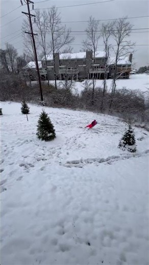 Daughter enjoys snow sliding fun in the backyard in Florence, Kentucky, USA