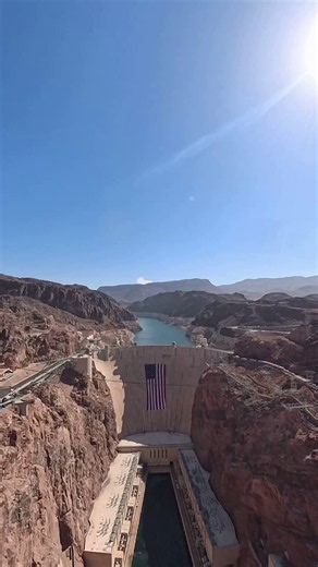 U.S. Air Force Thunderbirds over Hoover Dam, six F-16s in delta formation with a flag draped on the dam.