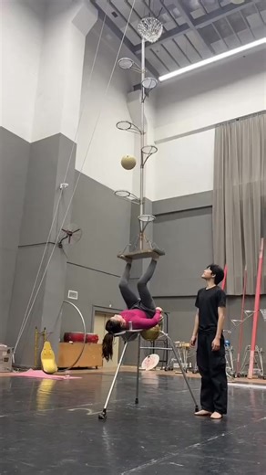 sarah on Instagram: "an acrobatic balancing act in what appears to be a studio or practice space. The performer is balancing on a specialized prop consisting of a tall pole with multiple small basketball hoops attached, a type of performance often seen in circuses or as a balancing skills demonstration. This specific act is a display of high-level balance, core strength, and coordination. #highlightsシ゚ #post"