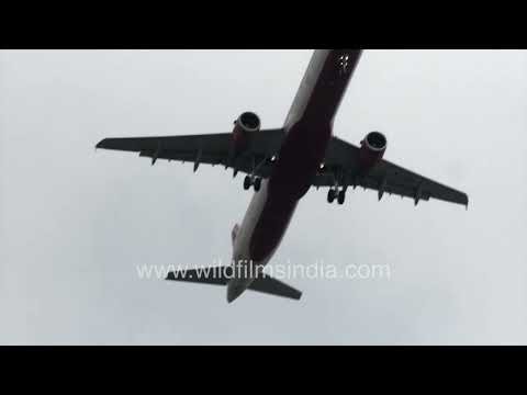 Commercial airplane flying across a cloudy Delhi sky