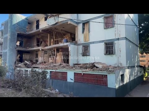 Venezuelan residents sift through rubble of buiding damaged during US attack