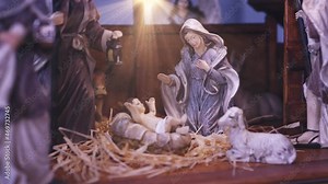 Jesus Christ Nativity scene with figurines in stable and light particles. Jesus Christ birth in a manger with Mary and Joseph. Christmas scene. Dolly shot 4k