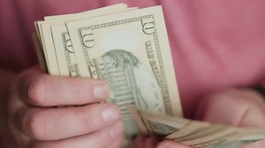 clip-3638577097-closeup-hands-counting-cash-highlighting-importance ...