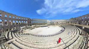 Tourist woman inside Pula Amphitheater or Coliseum of Pula is a well-preserved Roman amphitheater, located in Pula, Istria, Croatia, Europe. Ancient Roman empire arena constructed in 27 BC - 68 AD.