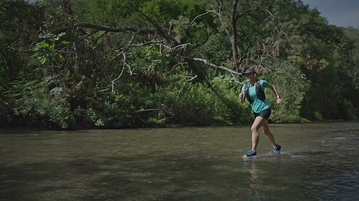 Woman and man jogging along a river in the forest - Free Stock Video