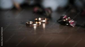 Gold wedding ring falls on the table in slow motion. Wedding accessory for the finger. Two loving hearts together forever. Wedding day, exchange of rings.