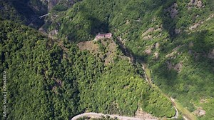 Poenari Citadel ruins with Vidraru Dam in foreground, surrounded by the majestic Fagaras Mountains, under a clear sky