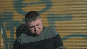 The guy smokes and coughs. Smoking is harmful.An adult man in a gray suit smokes a cigarette.
