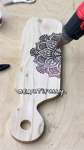 Here’s Exactly How I Made This Mandala Board! I sanded the pine board until it felt smooth, then added pretreatment to avoid bleeding. Next, I placed a mandala stencil off the edge - just enough to give the board a unique look. I scraped Scorch Paint across the stencil, used a brayer to remove the extra, and heated it until the design turned a rich brown. Then I finished it with our food-safe finishing oil to protect the surface and bring out the grain. And when I held the finished board, it jus