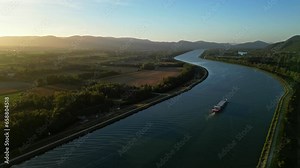 Panoramic view of the Rhone river bed in southern France with a passing passenger ship during sunrise on an autumn morning.