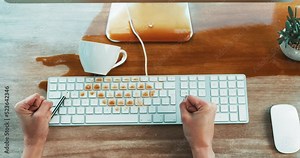 Clumsy woman spilling coffee on a computer and office table causing damage to her keyboard. A business female makes a mess on her desk with a splash of a hot beverage and needs accident insurance