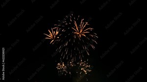 Golden shining fireworks exploding in the night sky. Glowing fireworks show. New year's or 4th of July fireworks celebration