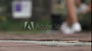 Low angle of brick path as college students walk past, extreme close up