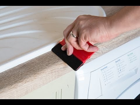 Applying sticky back plastic around the sink