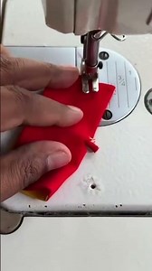 sewing on a cloth to insert a string in the middle of the cloth using a sewing machine