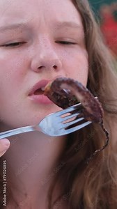 girl eats octopus with pleasure female traveler face to camera with a skewer food is excited about trying an exotic snack in Japan. asian youtuber. looking at camera is showing fans