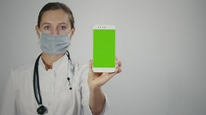 Female doctor displaying mobile with green screen - Free Stock Video