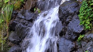 Waterfall trickling out of rocks in a tall mountain