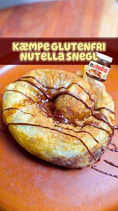 NUTELLA-SNEGL I AIRFRYER 🥐🍫 Du MÅ prøve den her! Den er sprød udenpå, blød indeni og smager som en lille himmelsk dessert 😍 Og det vildeste? Den har kun ca. 200 kalorier for en STOR snack! 💪 Du skal bruge: 🥣 1 banan 🥣 2 stk rispapir 🥣 10 g Nutella 🥣 1 æg 🥣 1/2 tsk kanel Sådan gør du: 1.Dyp rispapiret i æg og læg dem på bagepapir, så de overlapper lidt. 2.Skær bananen i skiver og læg dem i midten sammen med Nutella. Rul det hele til en pølse og derefter som en snegl 🐌 3.Drys med kanel o