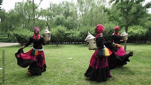 African women are dancing a folk traditional dance on a grass meadow, in traditional costumes with wicker baskets, sunny, trees' background, African costumes, traditions, African culture, tribes Stock Video