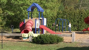Children swinging on swings at a small playground