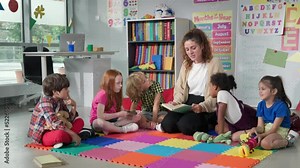 Female teacher reading story to group of elementary pupils in school classroom