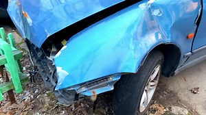 Broken wrecked smashed front headlight bumper hood car road collision accident on city street.Crashed vehicle automobile part outdoors.body insurance repair concept detail view