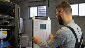 Print house worker setting parameters on modern offset printing machine