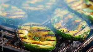 Seasoned avocado halves grilling on a hot barbecue grill. The avocado flesh is starting to brown and caramelize, creating a delicious smoky flavor