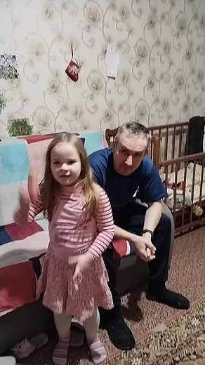 Young Girl Performs Handstand with Adult Supervision