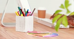 Businessman typing on a keyboard and drinking coffee at office