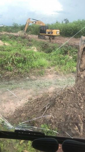 Excavator in Action: Digging a Muddy Field