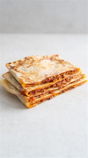 Julius Fiedler on Instagram: "Algeria’s Mhajeb 🇩🇿 This is Ep. 45 of Vegan Cultures, where I explore traditional plant-based food from around the world. The full recipe is on my website (link in bio) 👏 Mhajeb, also known as Mhadjeb or Mahdjouba, take flatbreads to the next level. The semolina dough is stretched out so thin that you can literally see your hand through it, before it is filled with harissa-spiced onions. The result is a soft, layered flatbread that is incredibly satisfying to eat