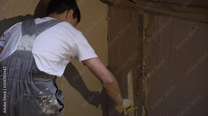 Plastering mortar machine. Automatic plaster. Repairing or renovating house or apartment. Builder at construction professional